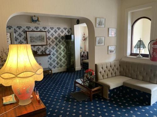 a living room with a couch and a lamp at Bramleigh Hotel in Blackpool