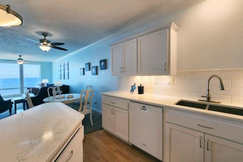 a kitchen with white cabinets and a dining room at Spectacular Ocean Front Condo with Community Club House & Pool! Whale Crossing in Depoe Bay