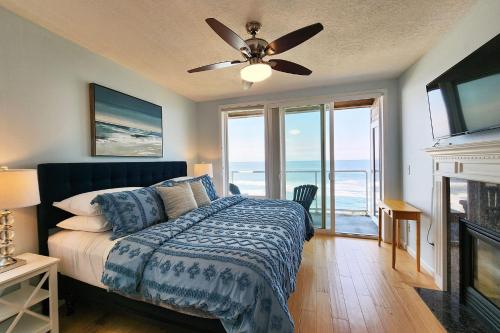 a bedroom with a bed and a ceiling fan at Spectacular Ocean Front Condo with Community Club House & Pool! Whale Crossing in Depoe Bay