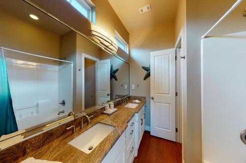 a bathroom with two sinks and a large mirror at Ultimate Ocean Views Game Room Dog Haven in Bolivar Peninsula
