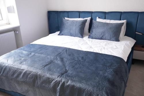 a bed with blue and white sheets and pillows at Luxury Apartments - Wohnung IA - Elegante Mini-Suite I Stock in Neuwied