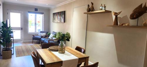 a living room with a dining room table and chairs at Sea 'n Summit Suite in Hermanus