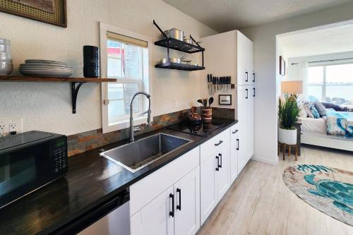 eine Küche mit Spüle und Mikrowelle in der Unterkunft Alsea Bay Cottage with Hot Tub! The Retreat in Waldport