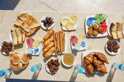 a table full of different types of food on plates at Sand pyramids hotel in Giza