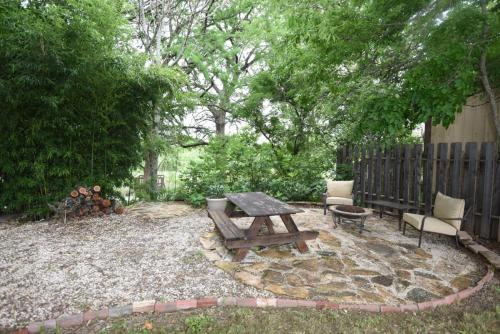 a wooden picnic table and chairs in a backyard at Jones Riverside Cabin in Utopia