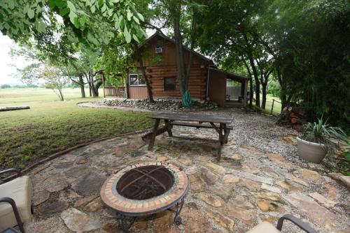 a fire pit in front of a log cabin at Jones Riverside Cabin in Utopia