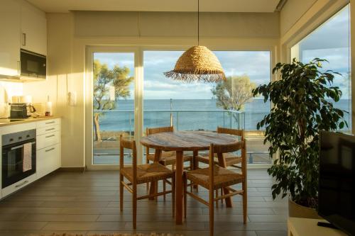 a kitchen with a table and chairs and a view of the ocean at Bay House in Ponta Delgada