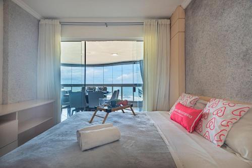 - une chambre avec une grande fenêtre et un lit avec une table dans l'établissement ITNC091 - Incrível vista para o mar com 3Q+3WC, à Balneário Camboriú