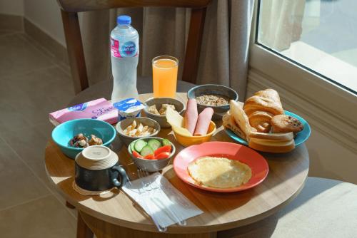 un tavolo con prodotti per la colazione e una bottiglia di succo d'arancia di Rock Pyramids Hotel a Il Cairo