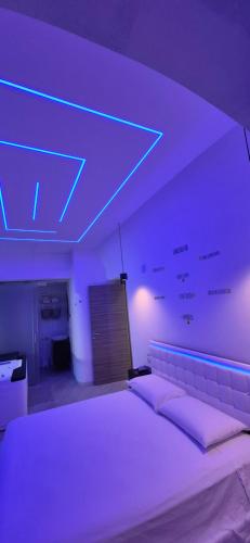 a bedroom with a large bed with purple lighting at Costantinopoli Suite in Giovinazzo