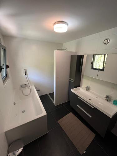 a bathroom with a tub and a sink and a toilet at Villa Bukvic in Zavidovići