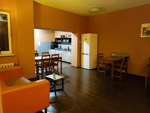 a kitchen and dining room with a table and a refrigerator at Jopi Hostel Katowice Centrum in Katowice