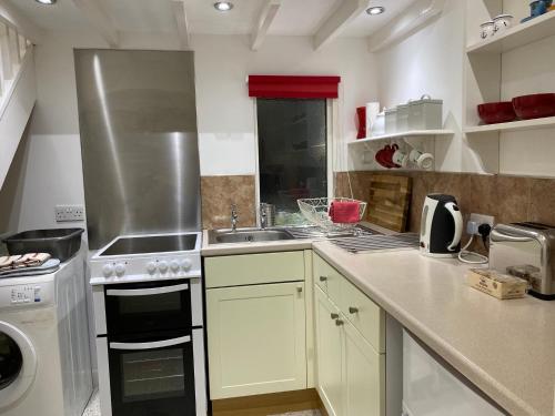 a kitchen with a sink and a stove top oven at Ty Aelwyd in St. Davids