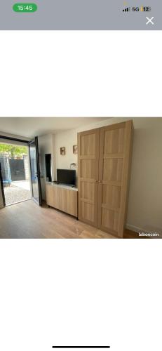 a kitchen with wooden cabinets in a room at Paris studio in Villeneuve-la-Garenne