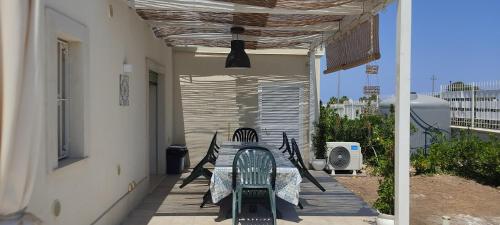 un patio avec une table et des chaises sur un porche dans l'établissement AltamareA Vacation home, à Brucoli