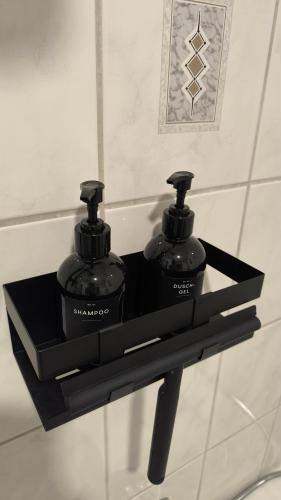 a black shelf with two bottles on top of it at Tolle Lage - modern - zentral gelegen - 2 Zimmer Apartment in Horb am Neckar
