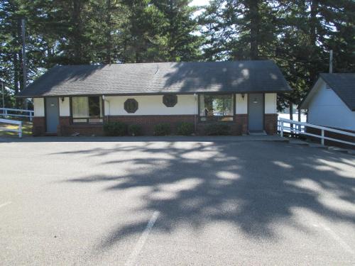 Woahink Lake Suites في Dunes City: منزل صغير أمامه شجرة