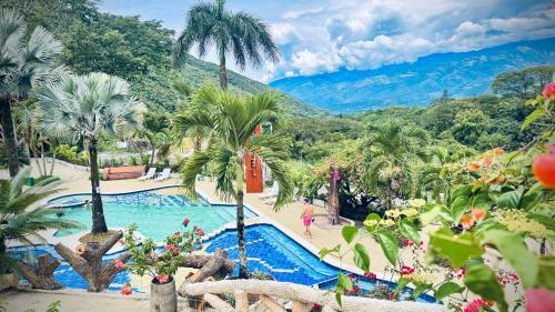 a resort swimming pool with palm trees and mountains in the background at Solvae EcoHotel in San Jerónimo