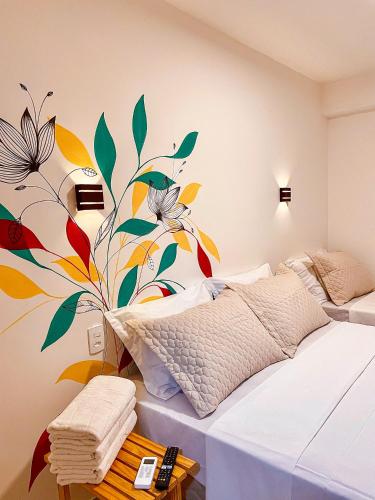 a bedroom with a mural of flowers on the wall at Pousada Solana in Salvador