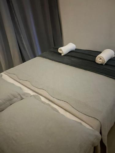 a bed with two rolled towels on top of it at Apartamento Central in Montes Claros