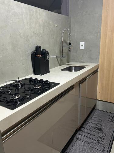 a kitchen with a stove and a sink at Apartamento Central in Montes Claros