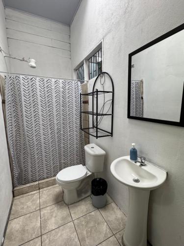 a bathroom with a toilet and a sink at Casa Pelíkano Uvita in Uvita