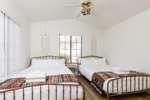 two beds in a room with white walls and a window at Western Hills-Heated Pool-In Fountain Hills in Fountain Hills