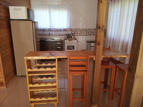 a kitchen with a wooden table and a refrigerator at Cabana Mundo Novo in Mundo Novo