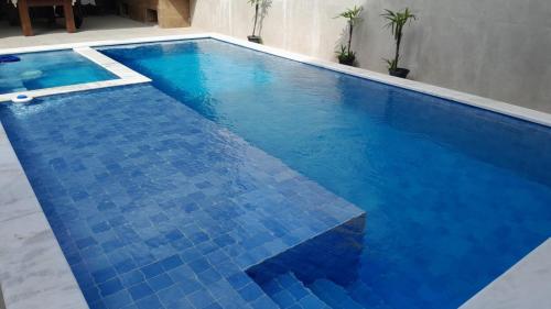a swimming pool with blue tiles on the floor at Pousada Coisa Nossa - Praia Cibratel II - 200m da praia in Itanhaém