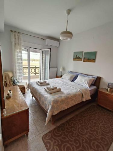 a bedroom with a large bed and a balcony at Polys Apartment and Paraskevi studio with view in Ptolemaida