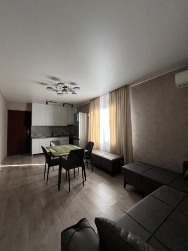 een woonkamer met een tafel en stoelen en een keuken bij Lucky Houseee in Grigoleti