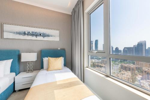 a bedroom with a bed and a large window at The Residences Towers - 3 Minute Walk to Dubai Fountain in Dubai