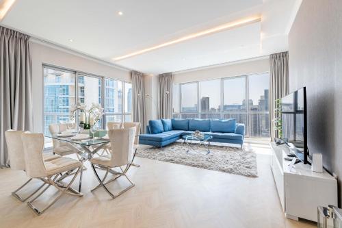 a living room with a blue couch and a glass table at The Residences Towers - 3 Minute Walk to Dubai Fountain in Dubai