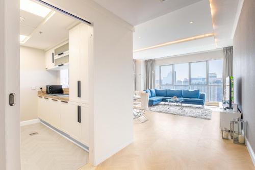 an open kitchen and living room with a blue couch at The Residences Towers - 3 Minute Walk to Dubai Fountain in Dubai