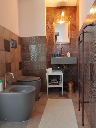 a bathroom with a tub and a toilet and a sink at Residenza Storella 18 in Alessano