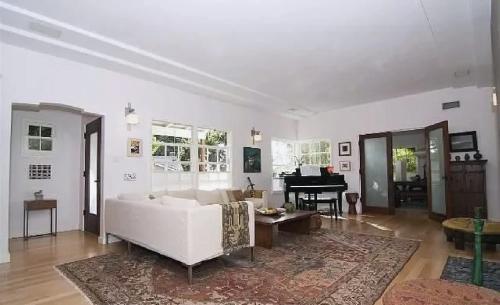 een woonkamer met een witte bank en een piano bij Tranquil 3 Bedroom Home in Santa Monica Canyon in Los Angeles
