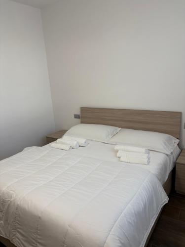 a large white bed with two white towels on it at Luino Family Retreat in Luino