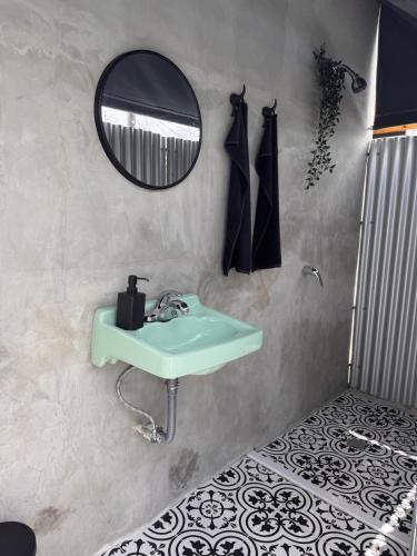 ein Badezimmer mit einem grünen Waschbecken und einem Spiegel in der Unterkunft AGA House Vacation Rental in Carolina