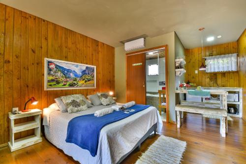 a bedroom with a bed in a room with wooden walls at Pousada Chalé Suiço Bombinhas in Bombinhas