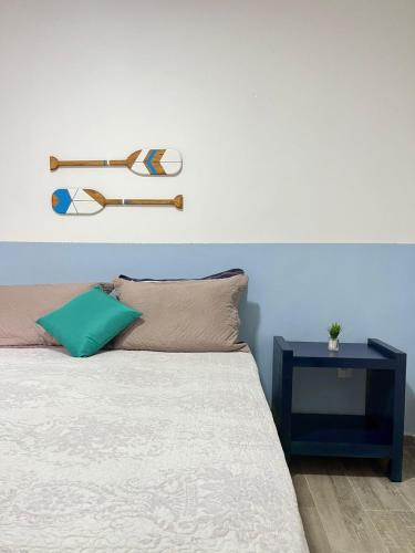 a bedroom with a bed with a blue wall at Studio no Centro com ESTACIONAMENTO GRÁTIS in Poços de Caldas