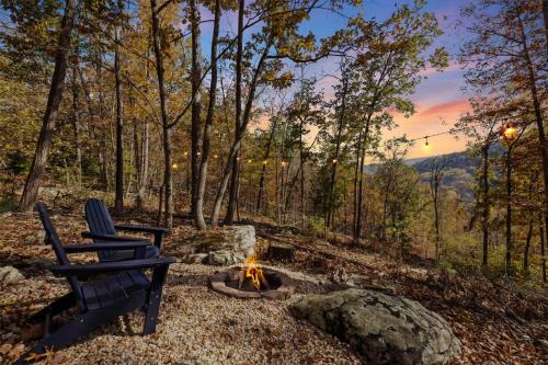 twee stoelen rond een vuurplaats in het bos bij Glamping Dome w Fire Pit WiFi King Bed & Bath in Wardensville