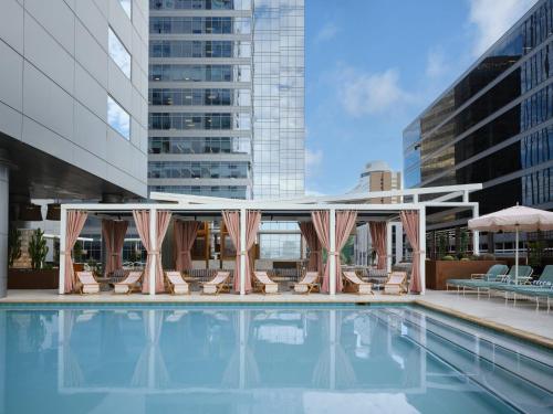 a pool with chaise lounge chairs and a pavilion at Kimpton Hotel Palomar Phoenix Cityscape by IHG in Phoenix