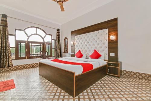 a bedroom with a large bed with red pillows at Hotel O Hameed in Durgjan