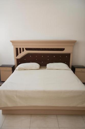 a bed with two pillows on top of it at السعادة للشقق المفروشة in ‘Aydīd