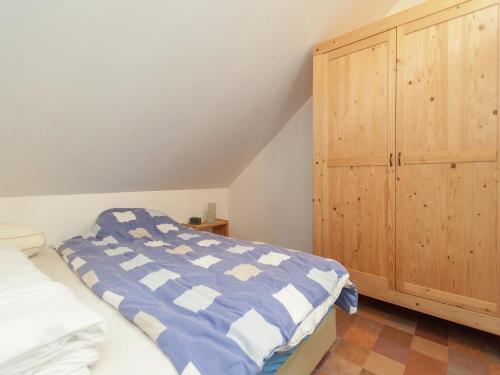 Un dormitorio con una cama y un armario de madera. en Holiday Home in Schoorl near Dunes, en Schoorl