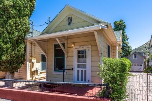 ein kleines gelbes Haus mit weißer Tür in der Unterkunft Copper Queen Cottage in Bisbee
