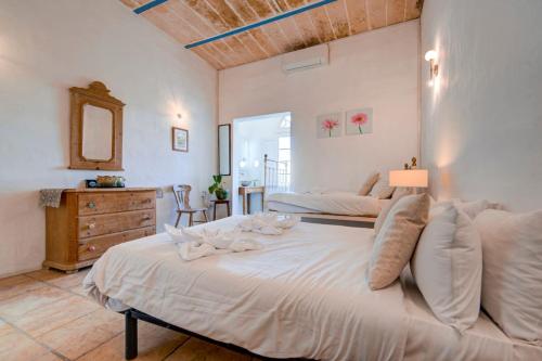 a large white bedroom with two beds and a dresser at Villa Josette with Pool Table and Garden by Haven and Keys Malta in Tal-Għoqod