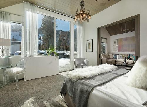 a bedroom with a large bed and a living room at Elegant Aspen Chalet Steps to Gondola in Aspen