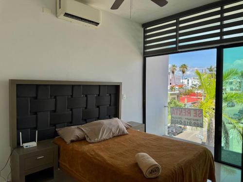 a bedroom with a large bed and a large window at Depa a unas Calles de la Playa By GPSRentas in Isla Venados