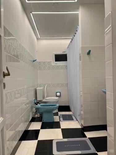 a bathroom with a blue toilet and a tiled floor at Casa bulgara boutique in Aristóbulo del Valle